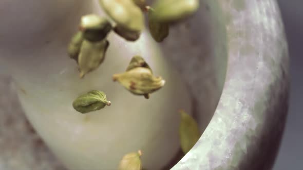 Granite Mortar and Cardamom Spice Species Falling in Slow Motion alt
