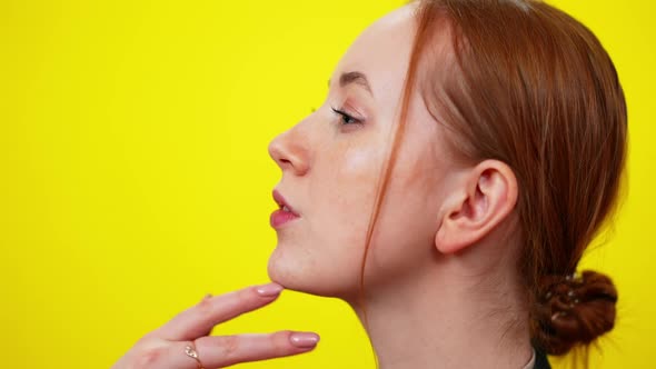 Side View Closeup of Freckled Redhead Young Woman with Green Eyes Touching Chin alt