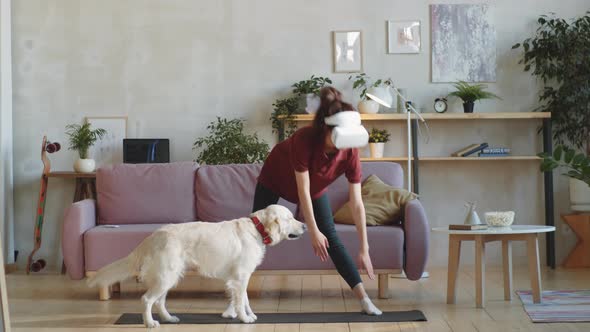 Woman in VR Headset Exercising in Living Room alt