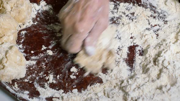 Wrinkled Hands of an Elderly Man Knead the Dough and Make Balls of Kolobok alt