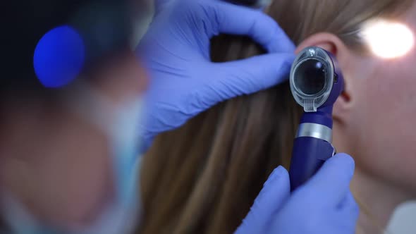 Closeup Otoscope in Hand of Professional Otolaryngologist Checking Auditory Canal and Tympanic alt