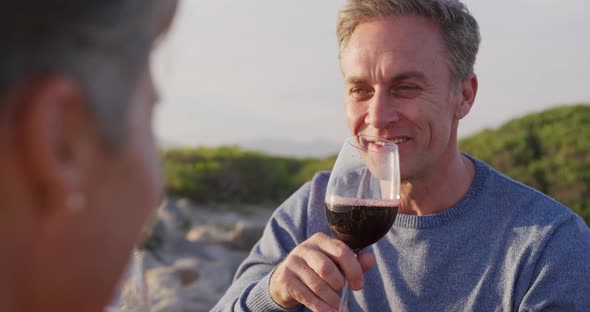 Couple drinking wine by the sea alt