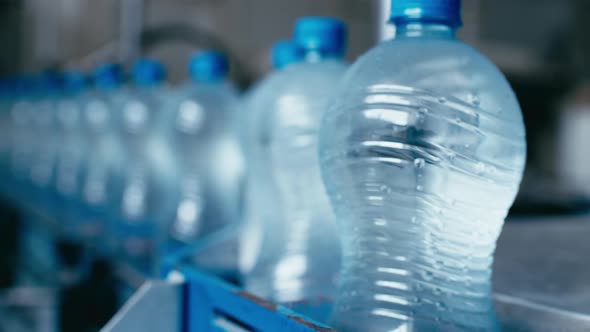 Water Bottles Moving on Automatic Conveyor Line in Water Production Factory