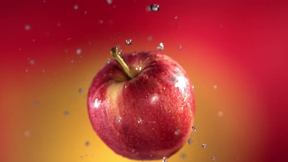 Flying of Red Apple in Red Yellow Background in Slow Motion alt