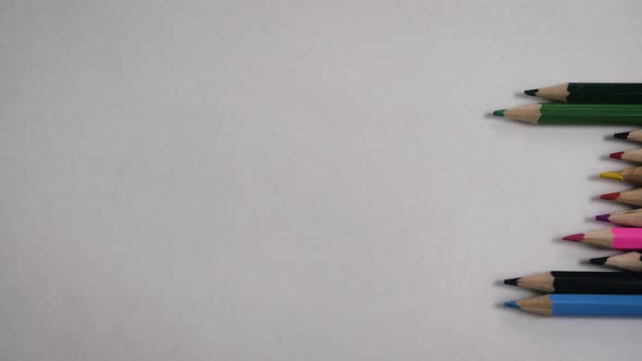 Multicolored Pencils Forming a Sound Wave on a White Background alt