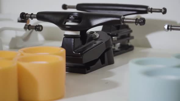 Close up skateboard parts, trucks, wheels, bearings on white desk. Smooth slider alt