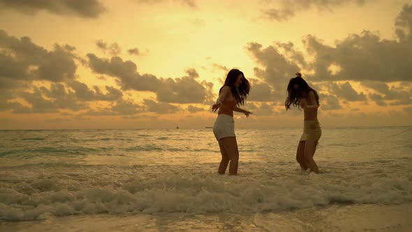 Two Asian girl friends are having fun on the beach while on vacation. concept of freedom, travel