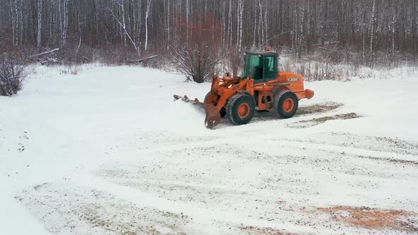 Piling up snow with a front end loader alt