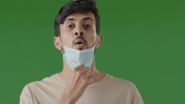 Exhausted Arab Brunet Man Indian Hispanic Guy Stands Isolated in Green Studio Takes Off Respiratory alt