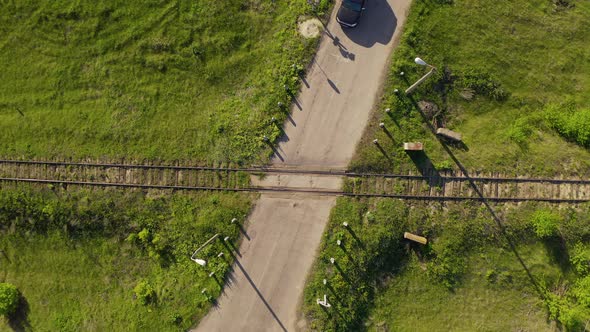 Vehicle Passing the Railroad Crossing at Rural Landscape. Top Down Aerial View