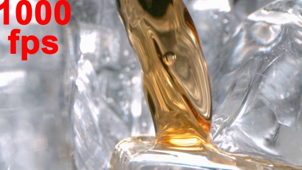 Super Slow Motion Of Whiskey Pouring In A Glass With Ice alt