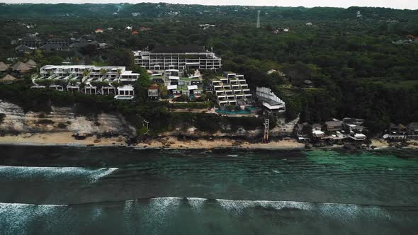 Beautiful Bingin beach with exotic cliffs houses and hotel located in Bali, Indonesia. This drone fo alt