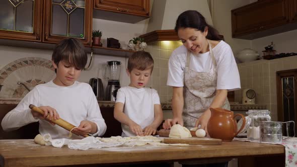 Mother with Two Sons is Preparing a Dough in Domestic Kitchen