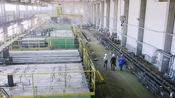 Crew foreman going through factory with guests