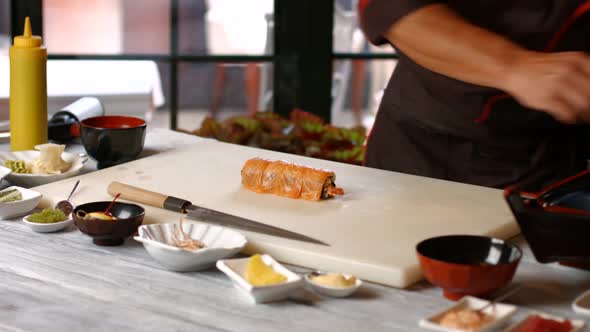 Man's Hands Making Sushi Rolls. alt
