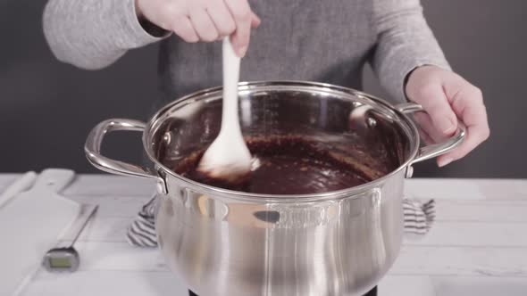 Step by step. Mixing ingredients in the cooking pot to make simple chocolate fudge. alt