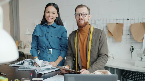 Young Tailors Standing in Workshop Together Smiling Looking at Camera alt