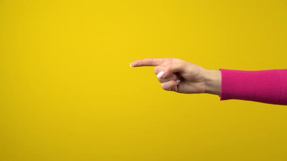 The Hand Shows the Index Finger To the Empty Space. Studio Shooting on an Isolated Yellow Background alt