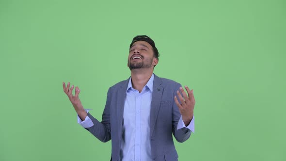 Happy Young Bearded Persian Businessman Catching Something alt