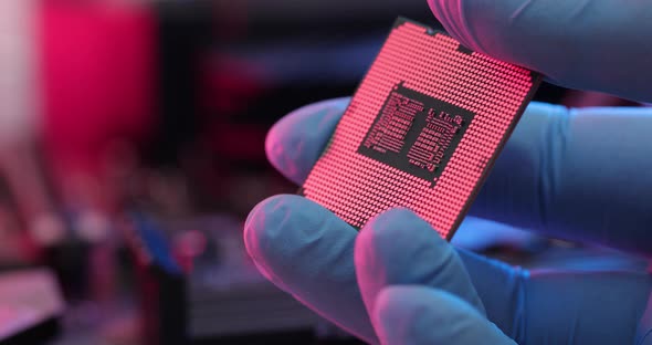 manipulating and installing processor on the motherboard in details with blur and selective focus alt