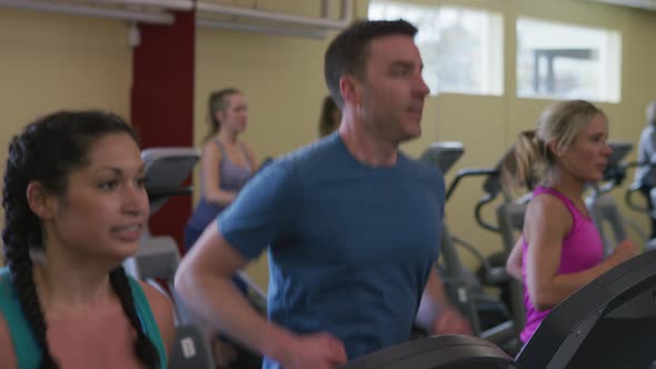 People running on treadmills at gym