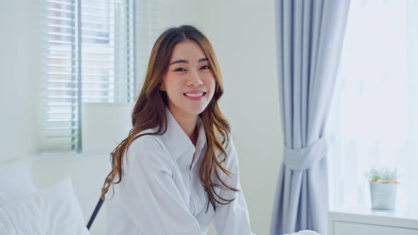 Asian young woman feel fresh and happy to wake up early from bed in bedroom in the morning at home. alt