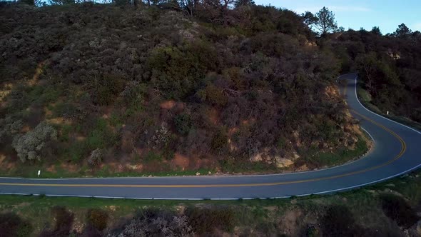 Tight Curve of Mountain Road beside Steep Cliff at Dawn, Drone Reveal alt