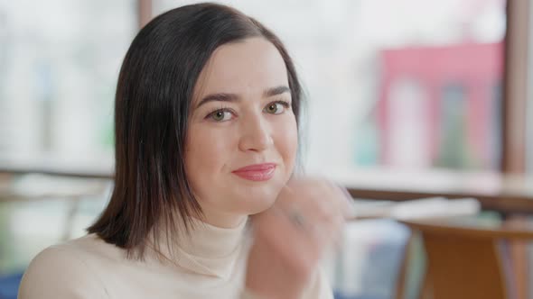 Closeup Portrait of Charming Young Woman with Hazel Eyes Looking at Camera Smiling alt