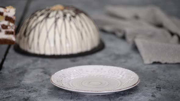 Piece of Pancho cake with pineapple and sour cream topped with chocolate and nuts. alt