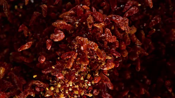 Super Slow Motion Shot of Dried Red Chili Peppers Explosion on Black Background at 1000Fps alt