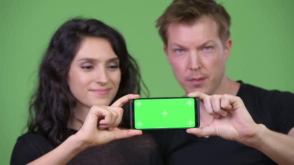 Young Couple Showing Phone Together alt