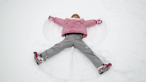 Little Girl Making Snow Angel alt