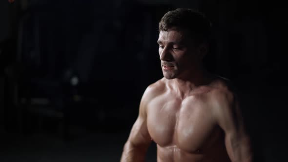 Athletic Man in the Gym Lifting Blocks on Rowing Machine Training on Block Device and Gym Equipment alt