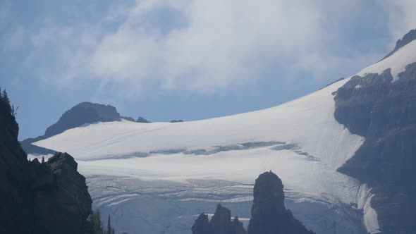 Clouds passing over snowy mountains alt