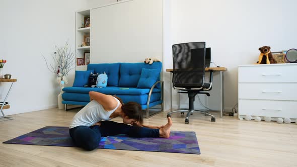 Young Woman Doing Yoga Marichi Pose At Home