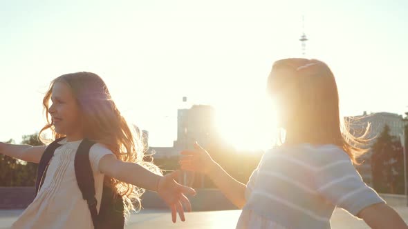 Two Little Girls Run Down Street To Female Teacher in Black, Three People Happily Hugging. Children alt