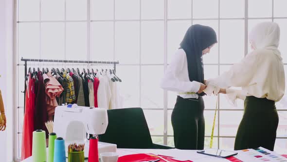 Muslim women fashion designers are in process of creating new clothes collection. alt