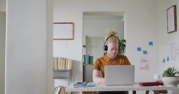 Albino african american man with dreadlocks making video call on the laptop alt