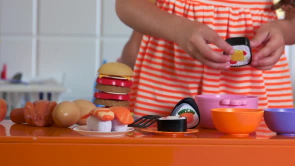 Close Up Kids Playing with Plastic Tablware in Playroom alt