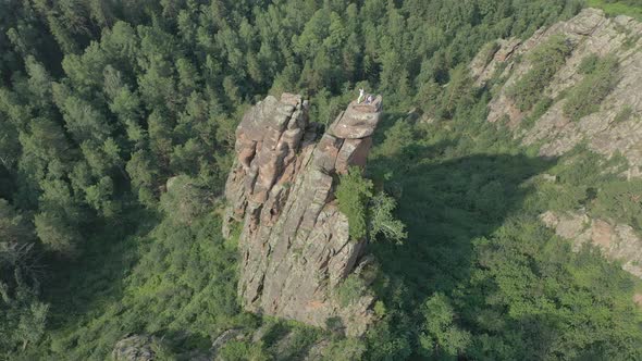 Top View of Two Hikers on Top of a Rock Mountain in the Siberian Forest