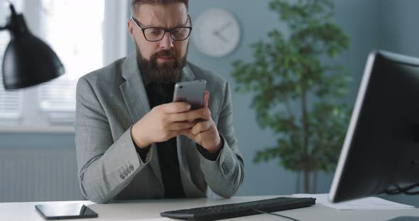 Businessman Using Mobile at Office