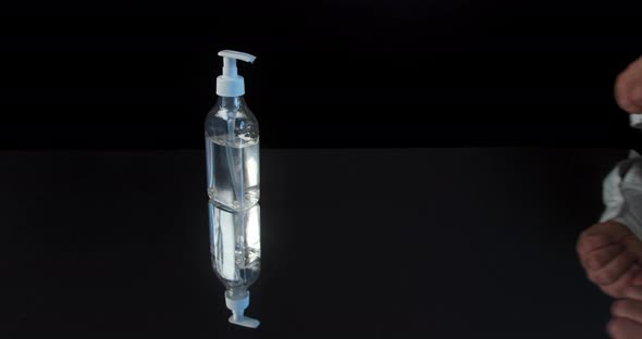 Man Push Dispenser and Liquid Soap Squeezed Out To Hand, Black Background.  alt