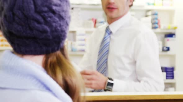Pharmacist giving medicine box to customer alt