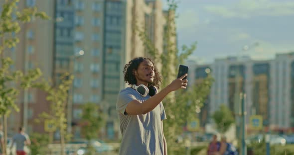 Young Man Walks Around the City and Takes a Picture with His Phone