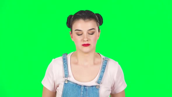 Girl Angry Covering Her Ears with Her Hands on Green Screen at Studio, Slow Motion. alt
