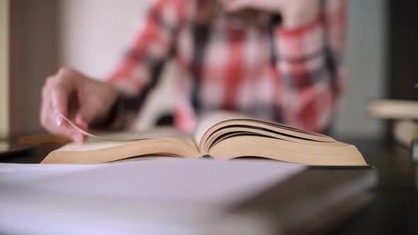 Girl leafing through a book. Close-up of pages from the end, selective focus alt