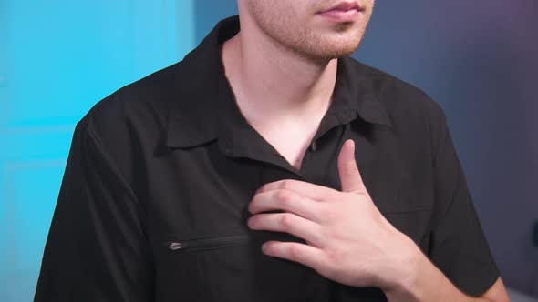 A Young Caucasian Male in a Medical Uniform Does a Selfmassage of His Chest Muscles with His Fingers alt