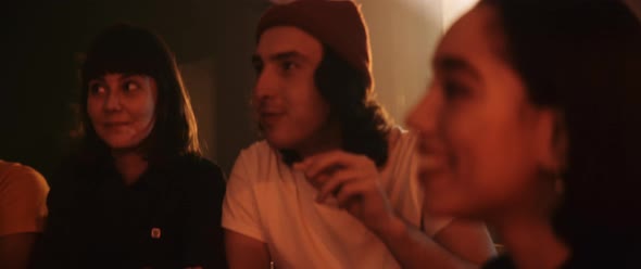 Group of friends in dark and red lights eating pizza and having fun alt