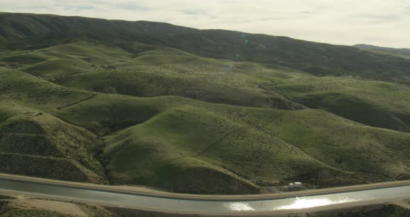Helicopter aerial shot moving over green farm fields, overcast day alt