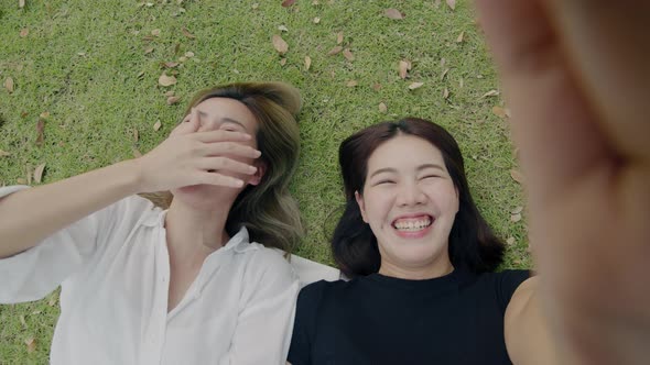 Asian woman friends taking selfie self-portraits video on smartphones.